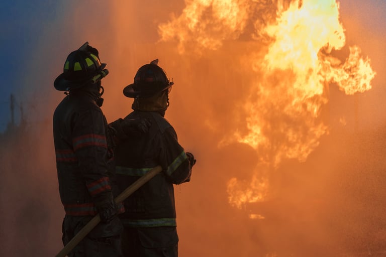 Firefighter spraying high pressure water at night