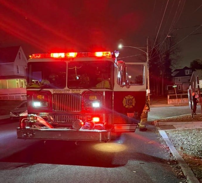 Red fire truck with emergency lights activated at night on a residential street