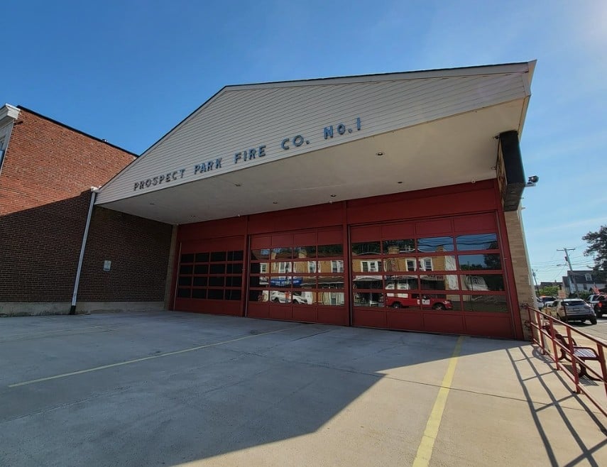 Prospect Park Fire Company No. 1 station exterior with red garage doors and brick facade on a clear day